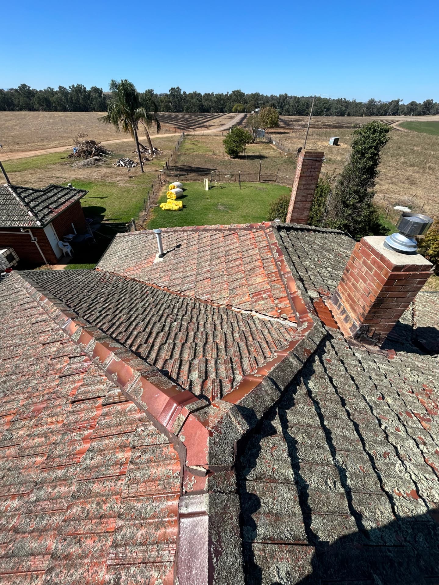 Weathered tiled roof before replacement, seen from above during an inspection